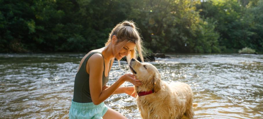 Frau mit Hund am Wasser